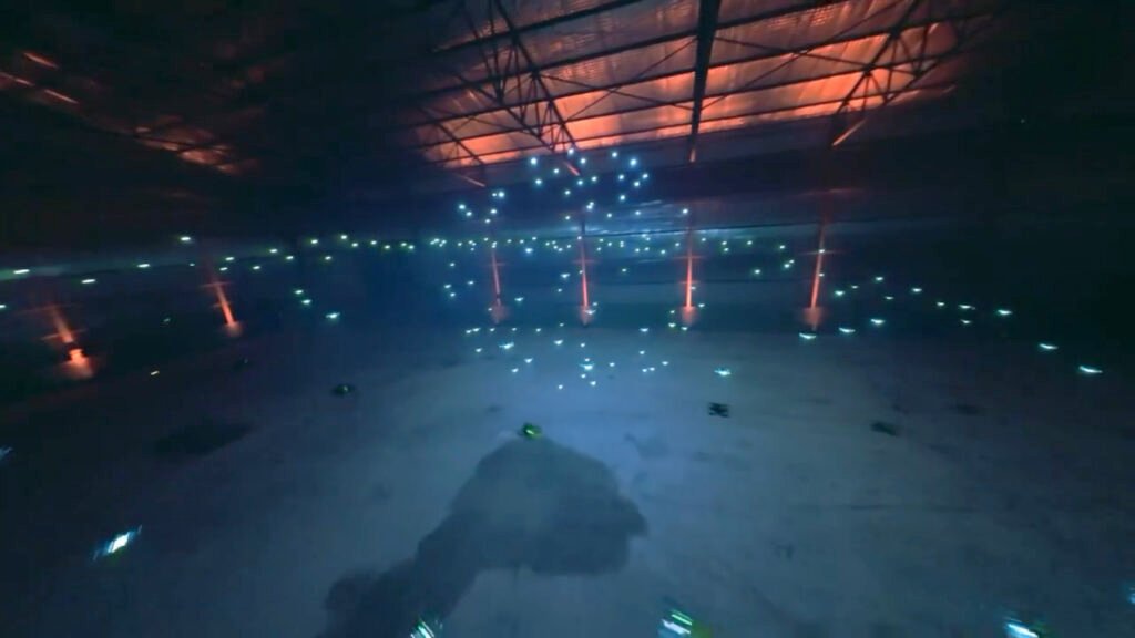 Drones creating light patterns indoors.